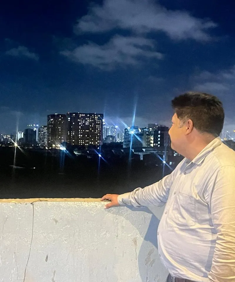 Shubham Kaushik looking out over a city skyline at night